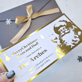 Gold and white Christmas dinner reservation card with Santa Claus illustration on a gray envelope.