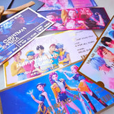 Collection of K-pop themed birthday invitations on a flat surface
