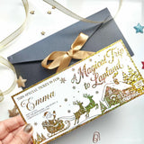 A festive gold and green foil keepsake ticket for a magical trip to lapland in a kraft envelope with santa sleigh design