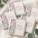 Pastel-colored mini neapolitan chocolates with floral and block lettering design for alphabet blocks shower celebration