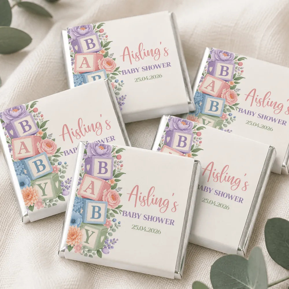 Pastel-colored mini neapolitan chocolates with floral and block lettering design for alphabet blocks shower celebration