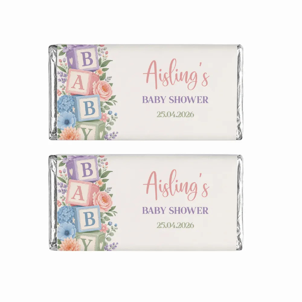 Pastel-colored baby shower chocolate bars wrapped in silver foil with floral and alphabet blocks shower design
