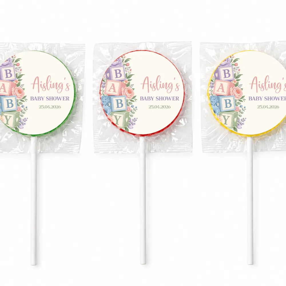 Three colorful baby shower lollipop favours with pastel floral alphabet blocks design on white sticks for alphabet blocks shower