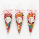 Three clear plastic sweet cones tied with pink ribbons filled with colorful gummy candies for aisling’s alphabet blocks shower