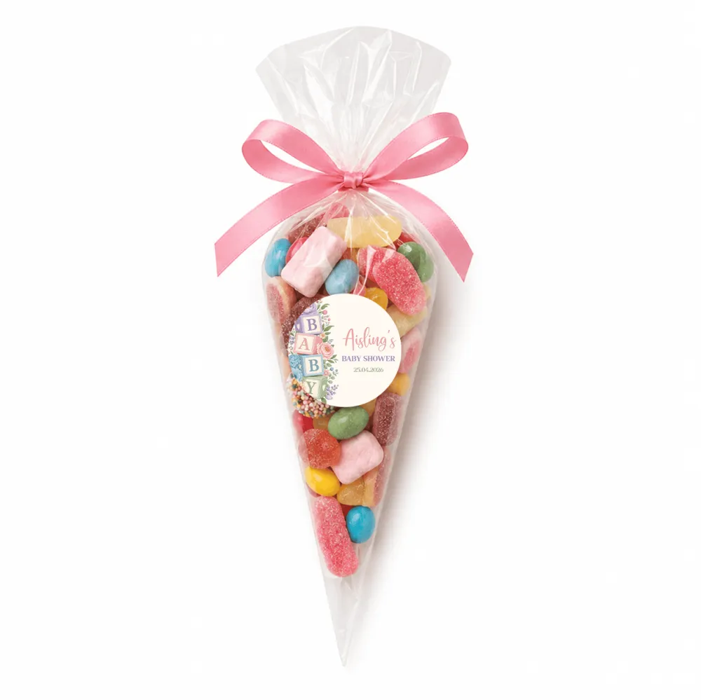 A clear cellophane sweet cone filled with colorful gummy candies tied with a pink satin bow for an alphabet blocks shower