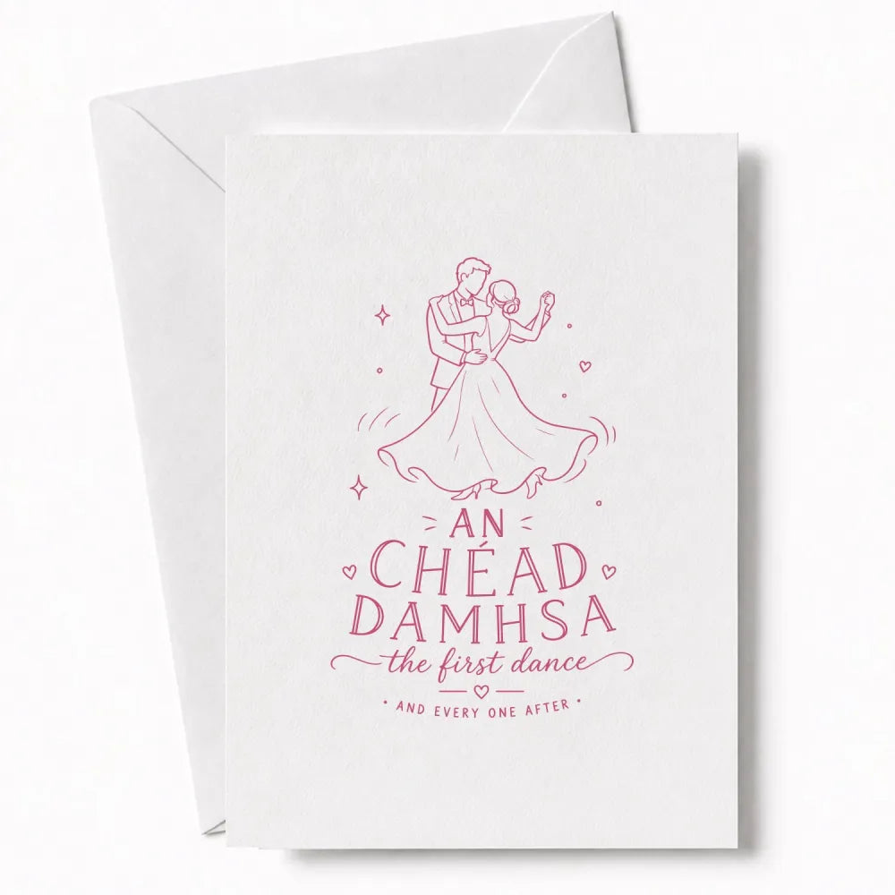 A white wedding card with a pink line drawing of a couple dancing and the text an chéad damhsa the first dance for wedding day cards