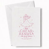 A white wedding card with a pink line drawing of a couple dancing and the text an chéad damhsa the first dance for wedding day cards