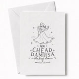 White wedding card with black line drawing of a couple dancing and text an chéad damhsa the first dance for wedding day cards