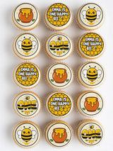 Cute yellow and black bumble bee cupcake toppers with honey pot designs for bee first birthday celebrations
