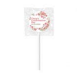 White lollipop favours wrapped in clear cellophane with pink floral wreath and blossoms for clara’s confirmation day