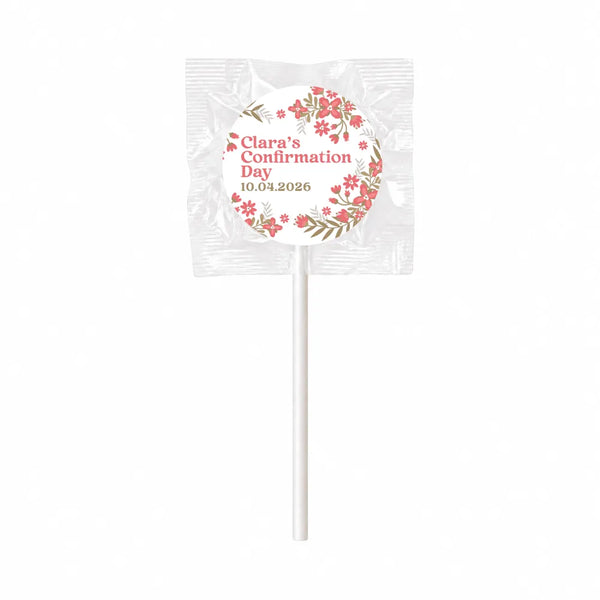 White lollipop favours wrapped in clear cellophane with pink floral wreath and blossoms for clara’s confirmation day