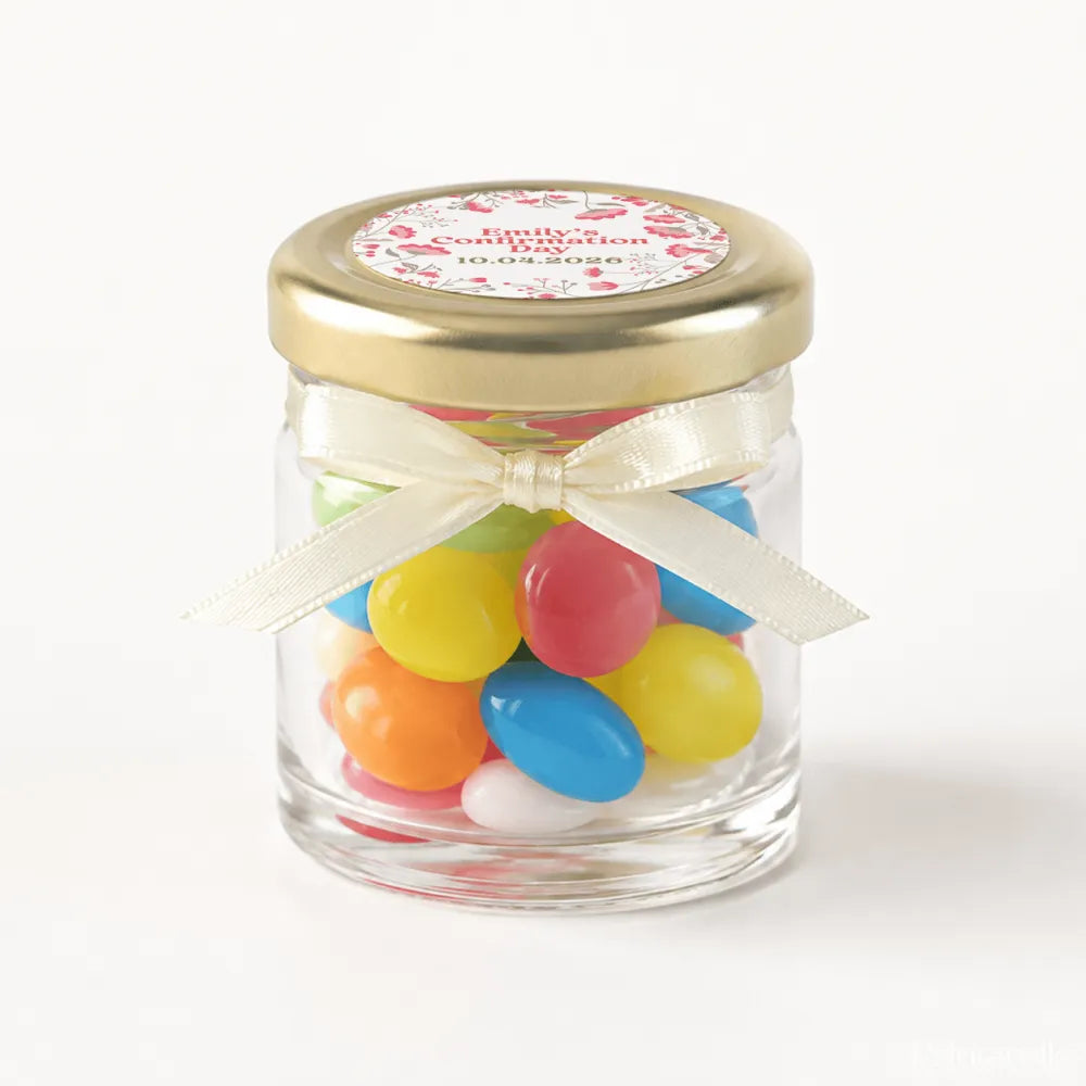 A clear glass mini jar favour with a 43mm pale gold twist lid, cream ribbon bow, and colourful jelly beans inside