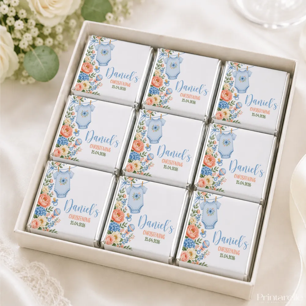 White chocolate mini neapolitan chocolates shaped like a blue onesie with floral designs for daniels christening