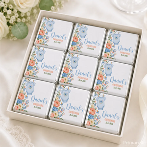 White chocolate mini neapolitan chocolates shaped like a blue onesie with floral designs for daniels christening