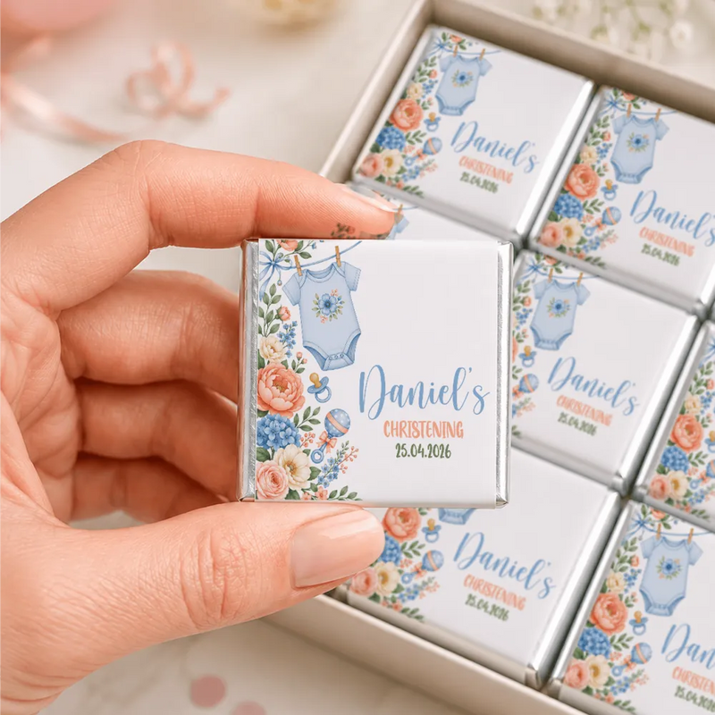 A delicate square silver foil wrapped mini neapolitan chocolate with blue onesie and floral design for christening