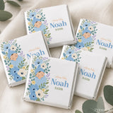 White chocolate mini neapolitan chocolates wrapped in silver foil with blue floral design and baby noah illustration