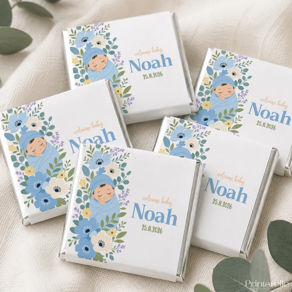 White chocolate mini neapolitan chocolates wrapped in silver foil with blue floral design and baby noah illustration