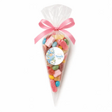 A clear plastic sweet cone filled with colorful gummies tied with pink satin ribbon and blue swaddle label noah