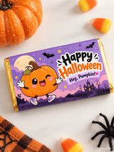 A purple and orange halloween chocolate box wrap for a 100g bar with a pumpkin cartoon and spooky night sky design