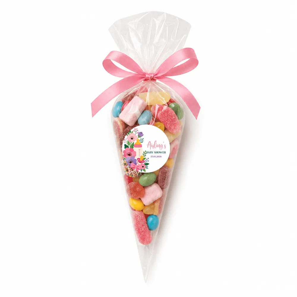 A clear plastic sweet cone filled with colorful gummies and marshmallows topped with a pink satin ribbon for a baby shower