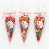 Three clear plastic sweet cones tied with pink ribbons filled with colorful candy for aisling’s baby shower gift