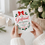White christmas greeting card with red bow and holly leaves for a girlfriend christmas card titled brighter every day