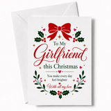 White girlfriend christmas card with red bow green holly and festive script reading to my girlfriend this christmas