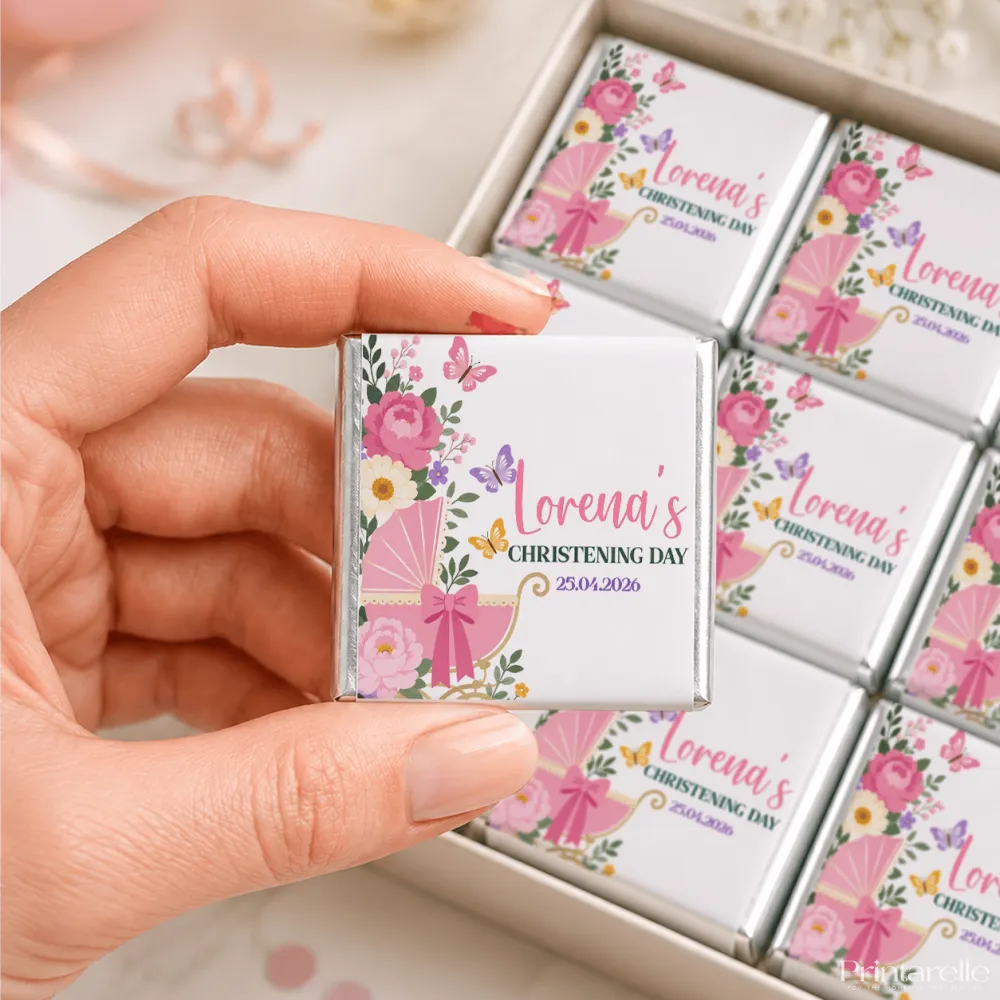 A pink and white floral mini neapolitan chocolate square with a baby carriage design wrapped in silver foil