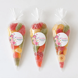 Three clear plastic sweet cones filled with colorful fizzy sweets with butterfly pram christening labels