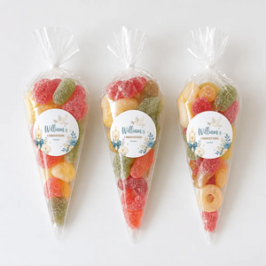 Three colorful sweet cones with shell design filled with assorted gummy candies for christening celebrations