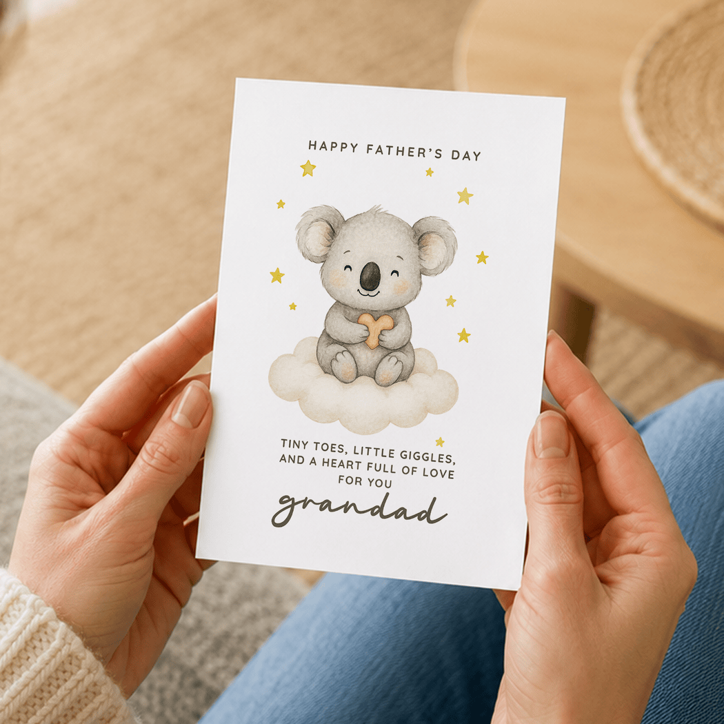 Person holding a Father's Day card with a koala illustration and text.