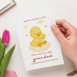 Hand holding a Father's Day card with a yellow duck illustration and text.