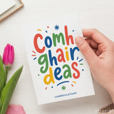 Colorful hand-held irish congratulations card with vibrant rainbow lettering and decorative elements saying comhghairdeas