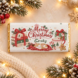 A personalised white christmas chocolate bar with gold foil edges and a cosy cat and books festive chocolate wrap