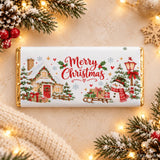 A festive white chocolate bar with gold foil edges and a christmas scene on a cosy cottage and snowman chocolate bar wrap