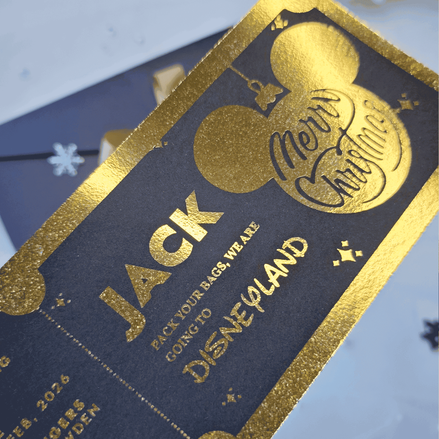 Gold-foiled luggage tag with 'Jack' and 'Disneyland' text on a blue background