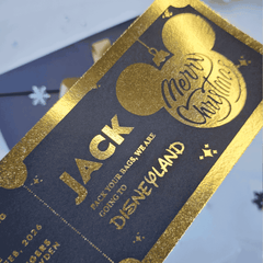 Gold-foiled luggage tag with 'Jack' and 'Disneyland' text on a blue background