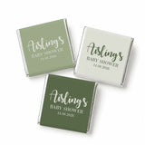Elegant script mini neapolitan chocolates wrapped in matte green and off-white paper for a baby shower favor