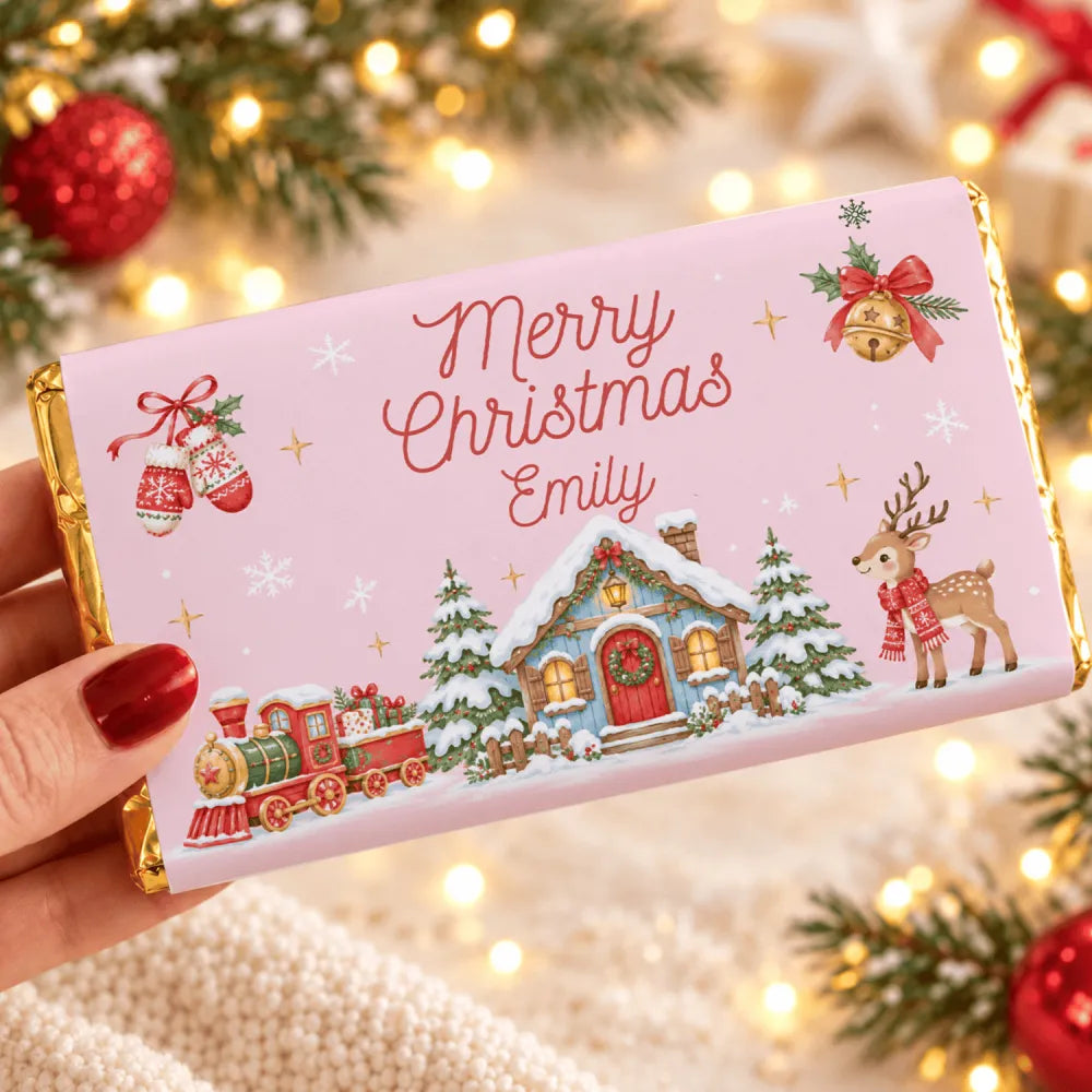 A personalized pink chocolate bar wrap with gold foil showing a festive cottage and steam train scene with merry christmas emily