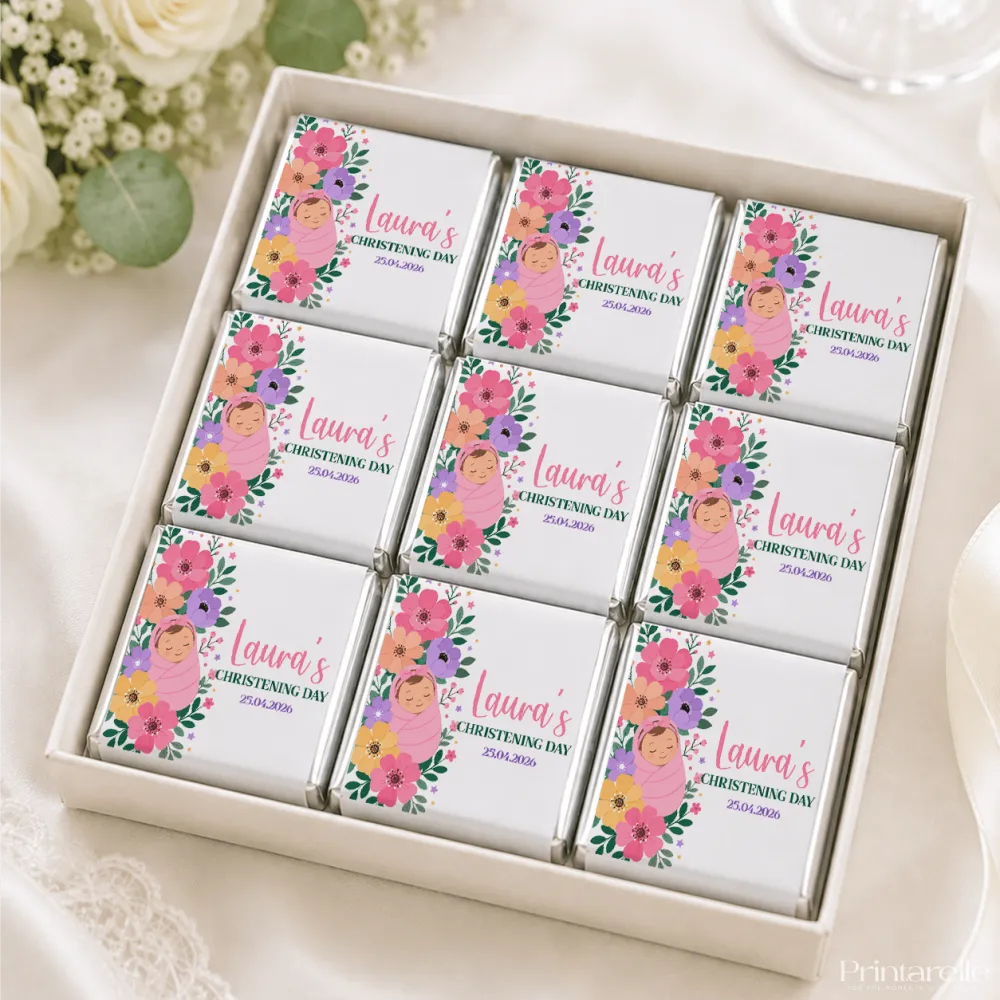 Nine mini neapolitan chocolates with colorful floral designs and lauras christening day text in white gift box