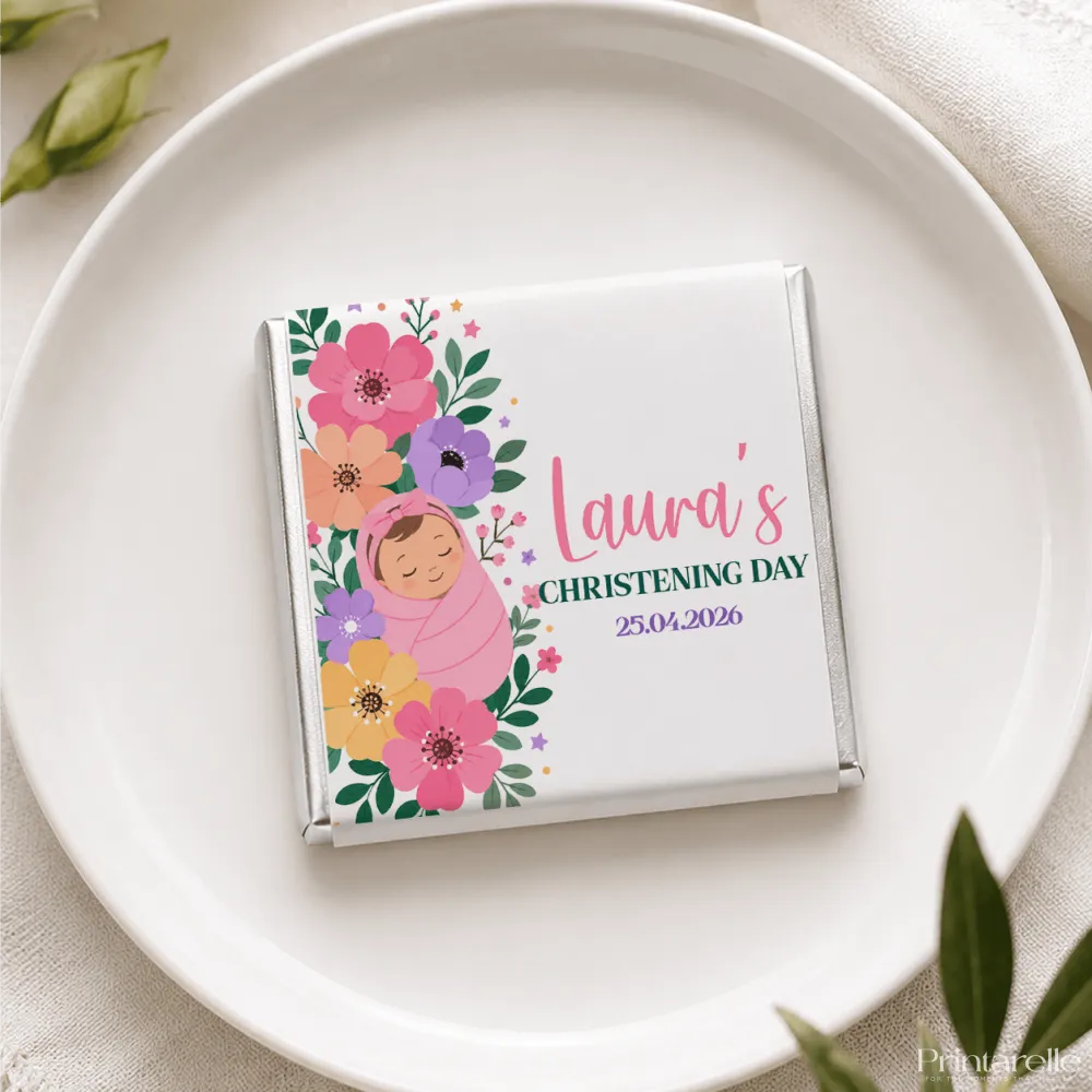 A personalized white chocolate mini neapolitan with pink purple yellow floral design and a wrapped baby illustration