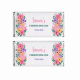 Two 40g chocolate bars wrapped in silver foil with floral swaddle labels featuring babies in pink blankets