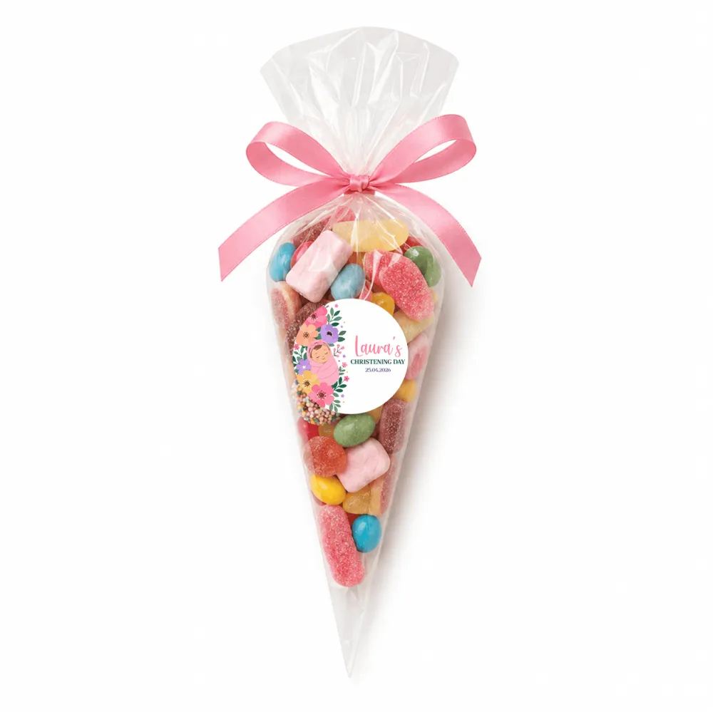 A clear plastic sweet cone filled with colorful gummies tied with a pink satin ribbon and floral swaddle sticker for christening