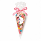 A clear plastic sweet cone filled with colorful gummies tied with a pink satin ribbon and floral swaddle sticker for christening