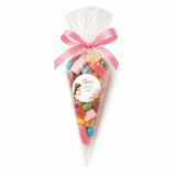 A clear plastic sweet cone filled with colorful gummy candies tied with pink ribbon and personalized label for communion