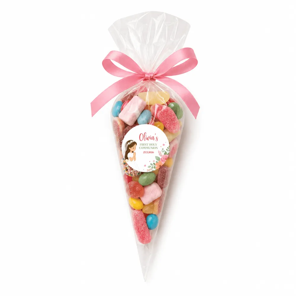 A clear plastic sweet cone filled with colorful gummy candies tied with pink ribbon and personalized label for communion