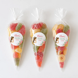 Three clear plastic sweet cones filled with colorful sugary gummy candies for floral veil communion sweet cones