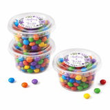 Clear plastic mini tubs filled with colorful candy sealed with floral wreath foiled purple stickers for weddings