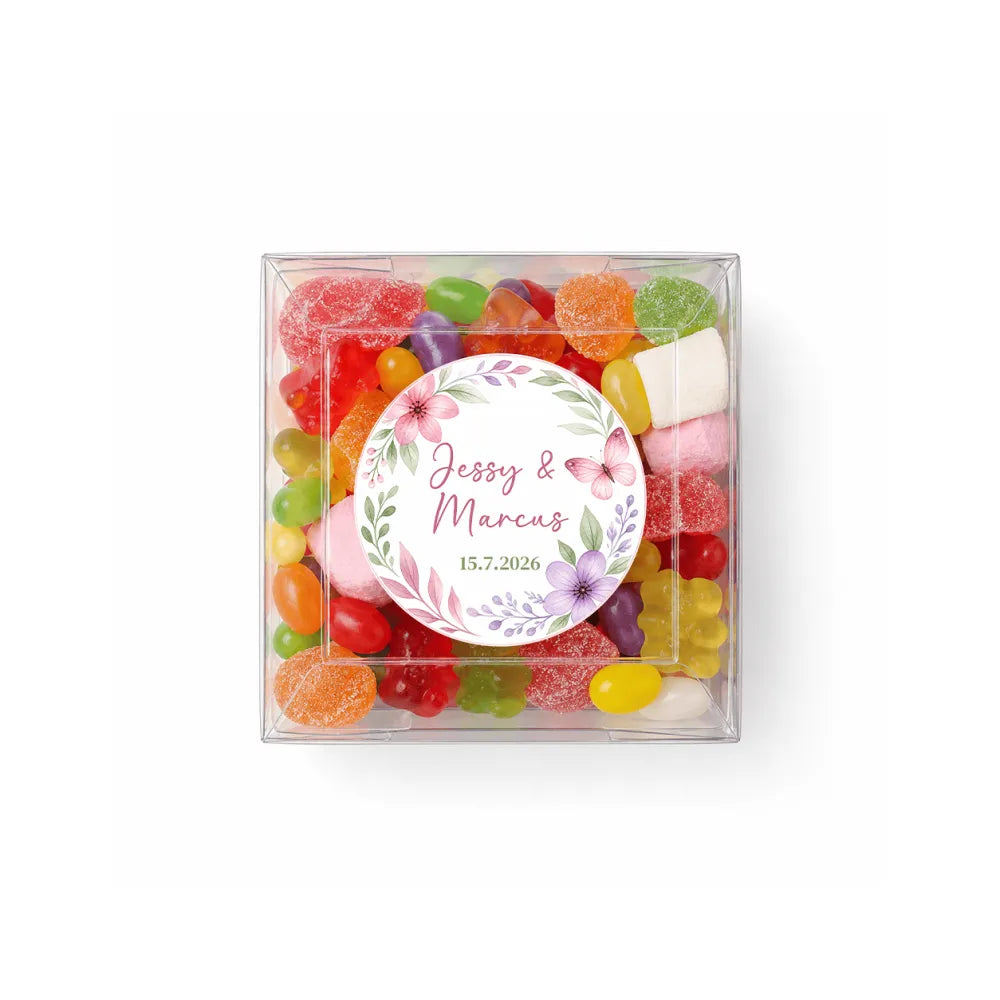 A clear box filled with colorful sugar-coated gummies and marshmallows perfect for floral wreath wedding dates