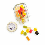 Clear glass jar with gold lid filled with colorful gummies for floral wreath wedding favours foil sticker hex jar